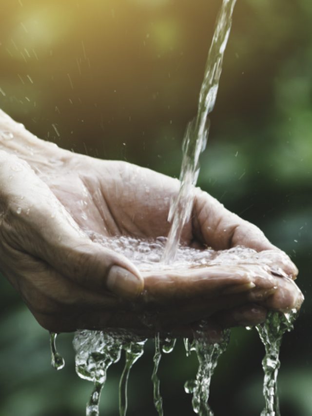 closeup water flow to hand of women for nature concept on the garden background.