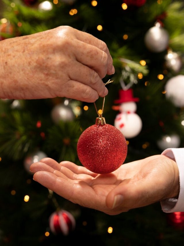 close-up-maos-segurando-uma-bola-de-natal_23-2148332029