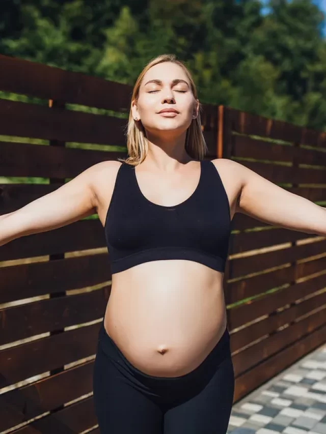 uma-mulher-gravida-usando-roupas-esportivas-medita-sobre-o-ar-puro-da-natureza-e-toma-banho-de-sol
