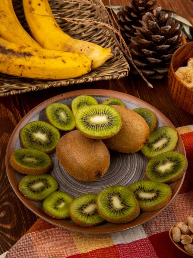 vista-lateral-de-fatias-de-kiwis-em-um-prato-e-cacho-de-bananas-em-uma-cesta-de-vime-na-madeira_141793-7256