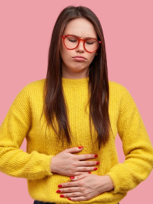 mulher-bonita-aperta-as-maos-na-barriga-sente-dor-e-desconforto-tem-problemas-de-saude-e-desconforto-alimentar-usa-sueter-amarelo-posa-contra-um-fundo-rosa_273609-25109
