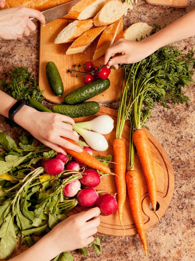 vista-superior-de-legumes-na-mesa-com-pessoas-preparando-os_23-2148610894
