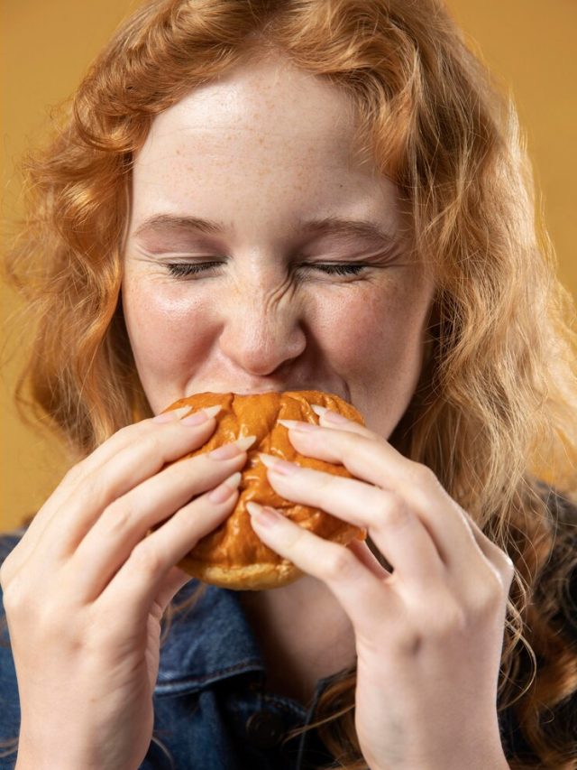 mulher-gostando-de-comer-um-hamburguer_23-2149003975
