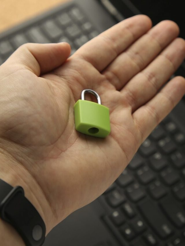 uma-mao-segurando-um-cadeado-verde-com-um-laptop-no-fundo-conceito-de-seguranca-cibernetica_181624-27999