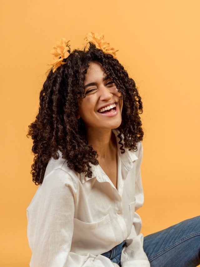 mulher-negra-com-flores-no-cabelo-a-rir_23-2148098495