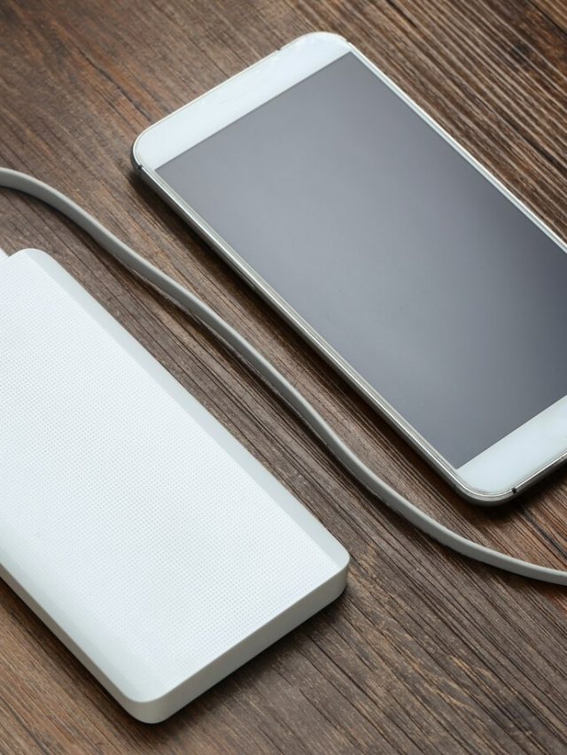 powerbank-e-celular-na-mesa-de-madeira_1387-513