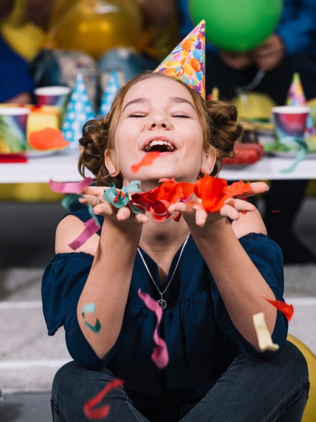um-menina-aniversario-desgastar-chapeu-partido-ligado-cabeca-segurando-confetti-caindo-ligado-mao_23-2148030065