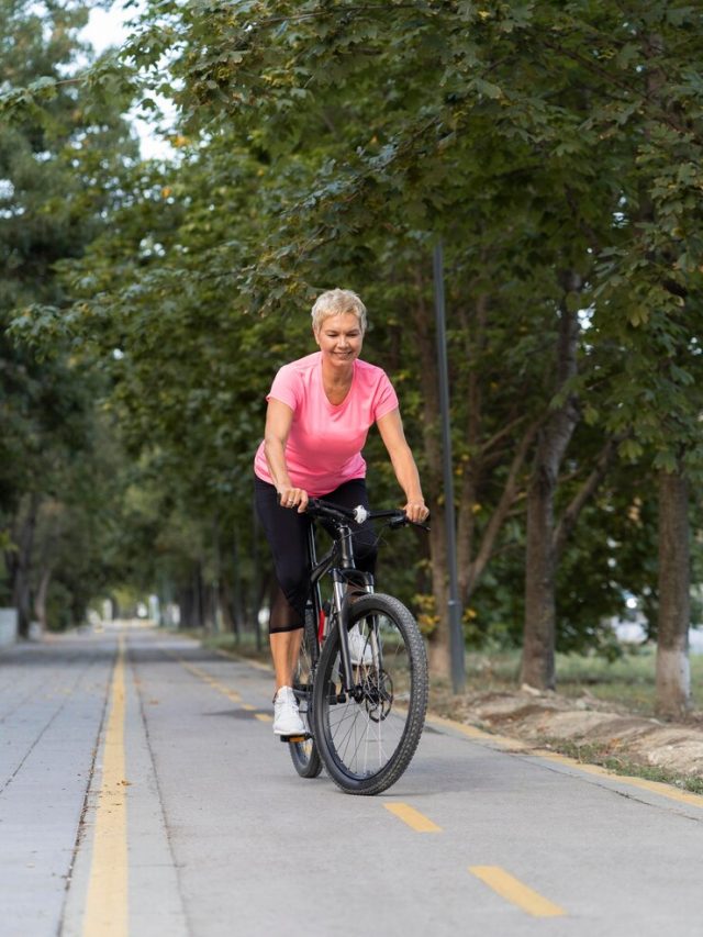 mulher-madura-sorridente-andando-de-bicicleta-ao-ar-livre_23-2148685752