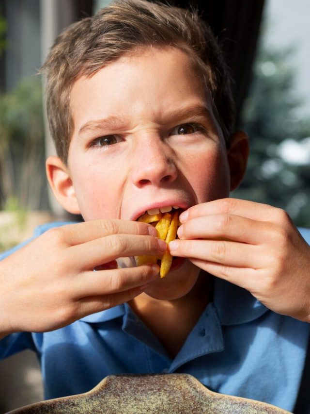 close-garoto-comendo-batata-frita_23-2148910404