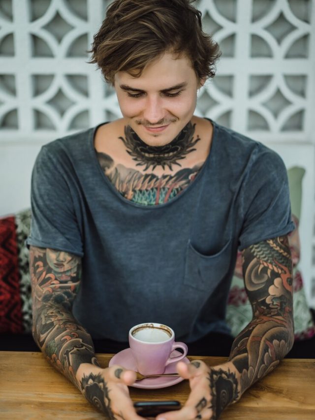 homem-tatuado-tomando-cafe-em-um-cafe_1321-902