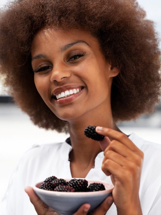 mulher-sorridente-de-vista-frontal-comendo-amoras_23-2150100264