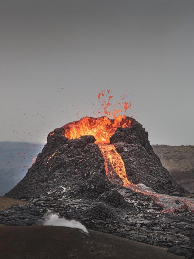 bela-foto-de-um-vulcao-ativo-com-lava-fluindo-e-fumaca-sob-um-ceu-claro_181624-56865