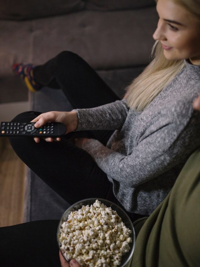 cortar-casal-assistindo-tv-no-sofa_23-2147771089