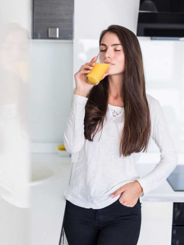 retrato-de-mulher-sorridente-feliz-bebendo-suco-de-laranja-fresco-na-cozinha_231208-519